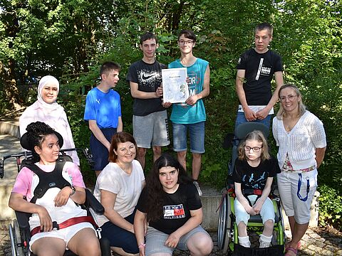 Gruppenfoto der Klasse M 8 der Pestalozzischule mit der Siegerurkunde 