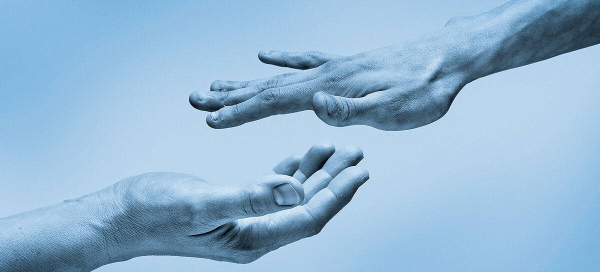 Zwei Hände, übereinender, die sich einander nähern. Die obere Hand zeigt mit dem Handrücken nach oben, die andere nach unten.