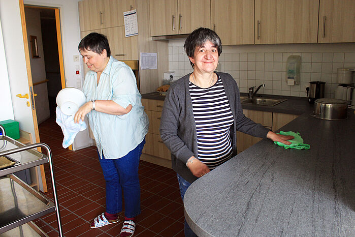 Zwei Bewohnerinnen in einer Küche beim Geschrirrabtrocknen und Arbeitsfläche Trochnen 