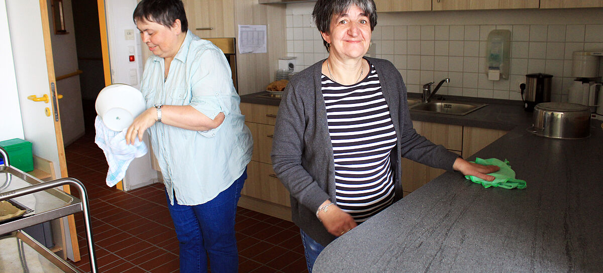 Zwei Bewohnerinnen in einer Küche beim Geschrirrabtrocknen und Arbeitsfläche Trochnen 